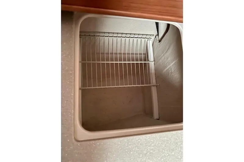 Slide: The Image of Empty storage compartment with wire rack inside a 2015 Catalina 315 boat. - 19