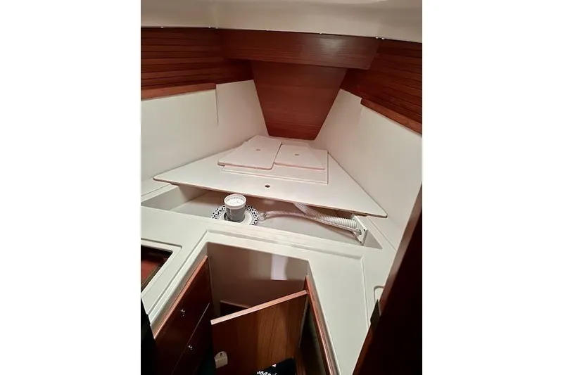 Slide: The Image of Interior cabin of a 2015 Catalina 315 sailboat, featuring wooden paneling and storage space. - 27