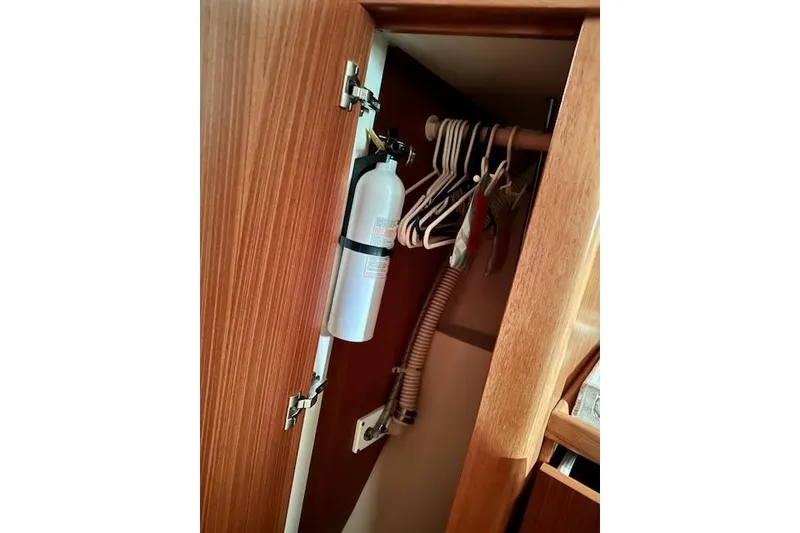 Slide: The Image of Cabinet interior on 2015 Catalina 315 yacht with fire extinguisher and hangers. - 28