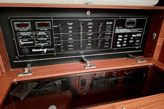 Slide: The Image of Electrical control panel of a 2015 Catalina 315 yacht, featuring various switches and meters. - 34