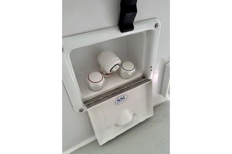 Slide: The Image of Water control panel on a 2015 Catalina 315 boat, featuring knobs and a hose connection. - 53