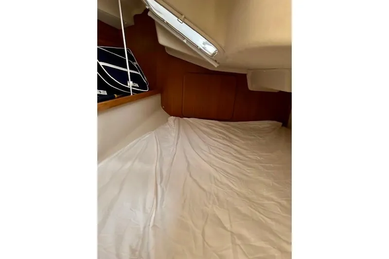 Slide: The Image of Interior cabin of 2015 Catalina 315 sailboat with white bedding and wooden accents. - 67