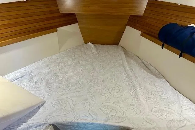Slide: The Image of 2015 Catalina 315 yacht interior with cozy bed and wooden paneling. - 8