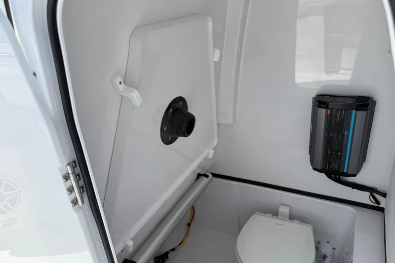 Slide: The Image of 2026 Sportsman Open 262 Center Console boat interior with toilet and electrical panel. - 16