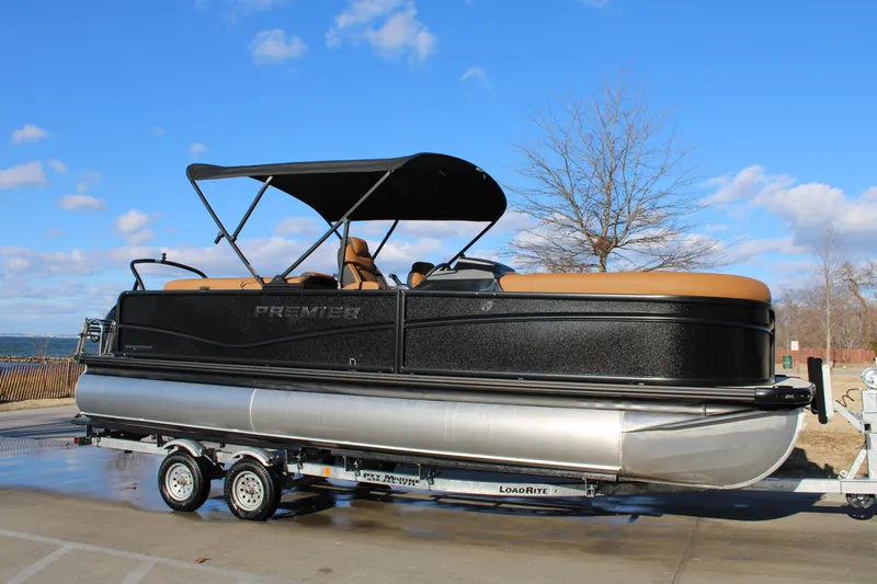 The Image of 2026 Premier 230 SunSation RF pontoon boat on trailer, under clear blue sky. - 0