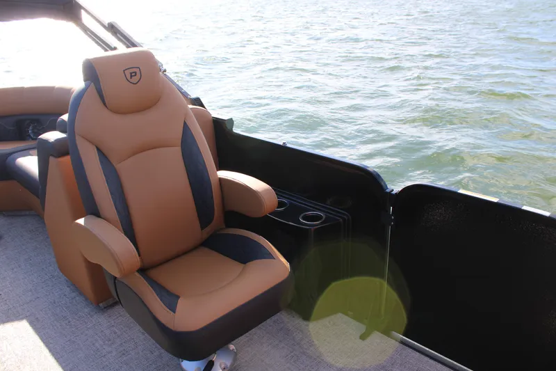 Slide: The Image of Luxurious seating on 2026 Premier 230 SunSation RF pontoon boat by the water. - 14