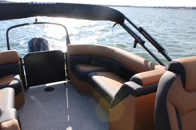Slide: The Image of 2026 Premier 230 SunSation RF pontoon boat interior with tan seating on a sunny day. - 15