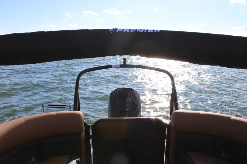 Slide: The Image of 2026 Premier 230 SunSation RF pontoon boat on shimmering water, rear view. - 17