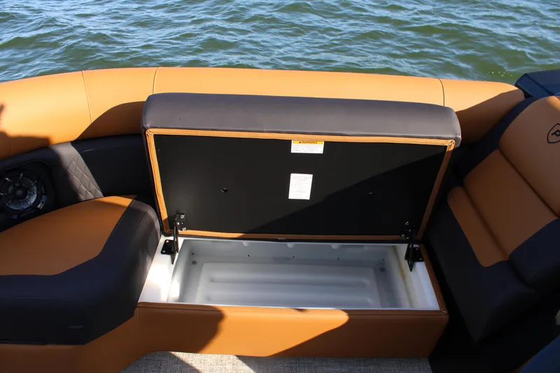 Slide: The Image of 2026 Premier 230 SunSation RF boat with open storage compartment, tan and black seating. - 8
