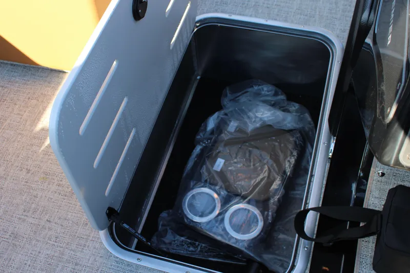 Slide: The Image of Open storage compartment in 2026 Premier 230 SunSation RF boat, showing interior contents. - 9