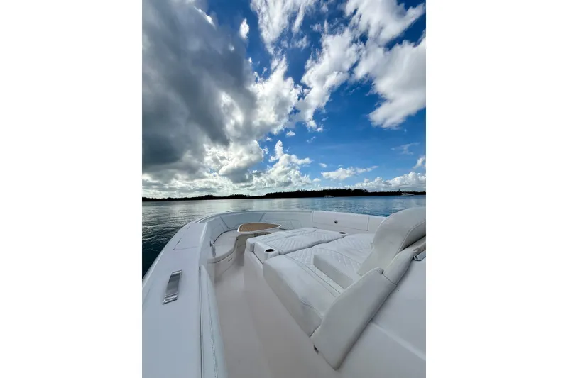Slide: The Image of 2022 Intrepid 407 Nomad SE boat on calm water under a partly cloudy sky. - 17