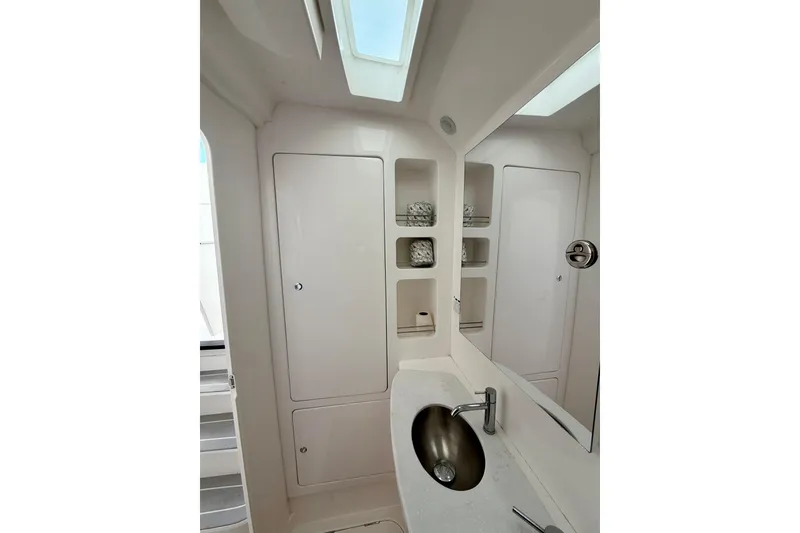 Slide: The Image of 2022 Intrepid 407 Nomad SE bathroom with modern sink, mirror, and storage shelves. - 24