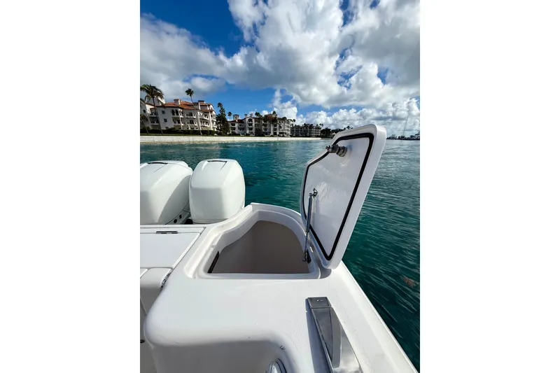 Slide: The Image of 2022 Intrepid 407 Nomad SE boat with open hatch, ocean view, and coastal buildings. - 25