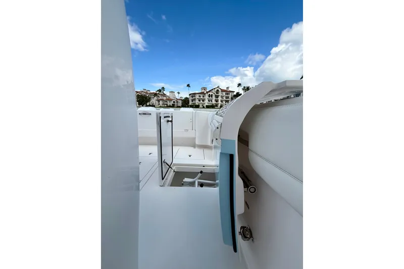Slide: The Image of 2022 Intrepid 407 Nomad SE boat interior with open hatch, blue sky, and buildings in background. - 26