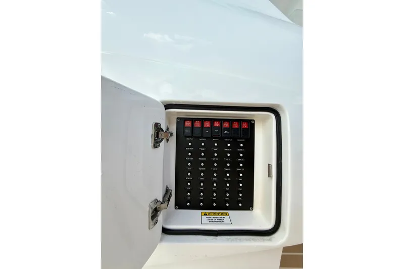 Slide: The Image of Electrical panel on 2022 Intrepid 407 Nomad SE boat, featuring labeled switches and warning label. - 28