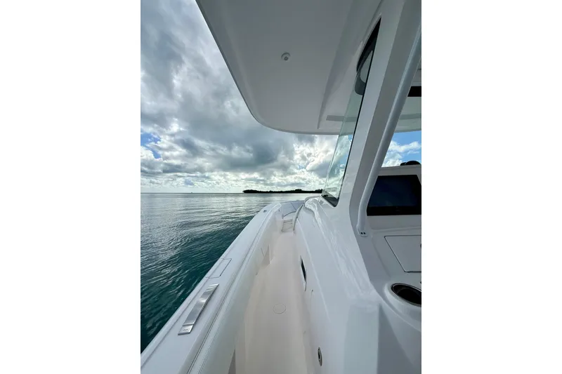 Slide: The Image of 2022 Intrepid 407 Nomad SE boat cruising on calm waters under cloudy sky. - 29