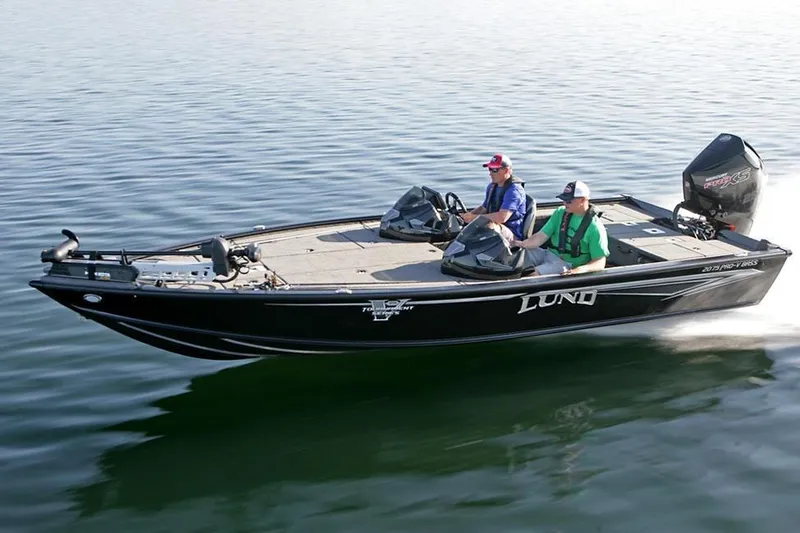 The Image of 2026 Lund 2075 Pro-V Bass XS boat cruising on a calm lake. - 0