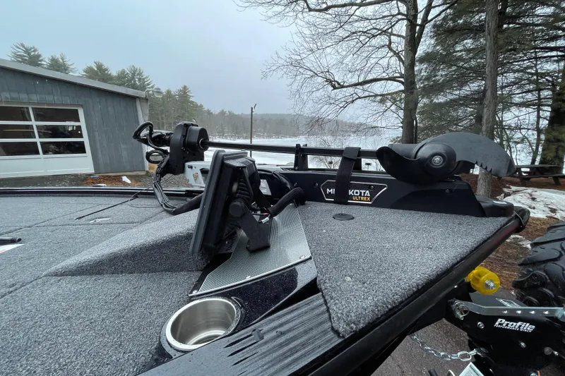 Slide: The Image of 2026 Lund 2075 Pro-V Bass XS boat with Minn Kota Ultrex motor, parked near a snowy lake. - 4