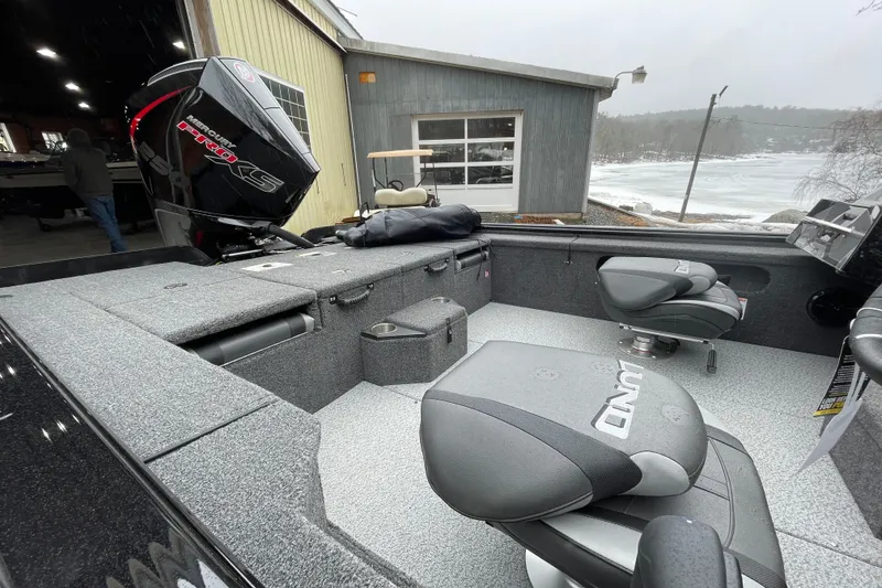 Slide: The Image of 2026 Lund 2075 Pro-V Bass XS boat interior with Mercury Pro XS engine, docked near a snowy lake. - 5