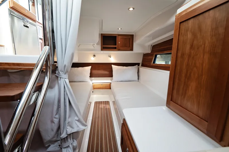 Slide: The Image of 2023 Back Cove 39O cabin interior with twin beds and wooden accents. - 18