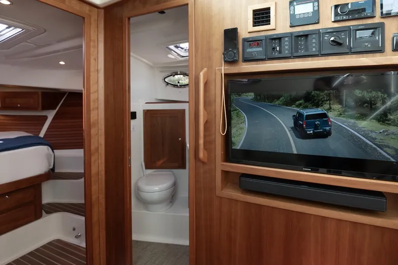 Slide: The Image of 2023 Back Cove 39O interior with TV, bathroom, and bedroom. Luxurious wood finish. - 22