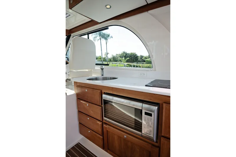 Slide: The Image of 2023 Back Cove 39O yacht interior kitchen with sink, microwave, and wooden cabinetry. - 28