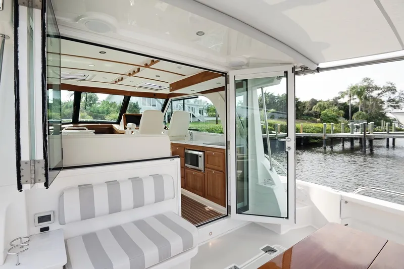 Slide: The Image of 2023 Back Cove 39O yacht interior with open doors, showcasing elegant seating and cabinetry. - 35