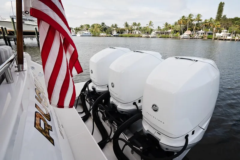 Slide: The Image of 2023 Back Cove 39O boat with triple outboard engines and American flag. - 49