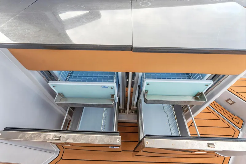 Slide: The Image of 2021 Aviara AV36 OB boat interior with open stainless steel drawers and wooden flooring. - 20