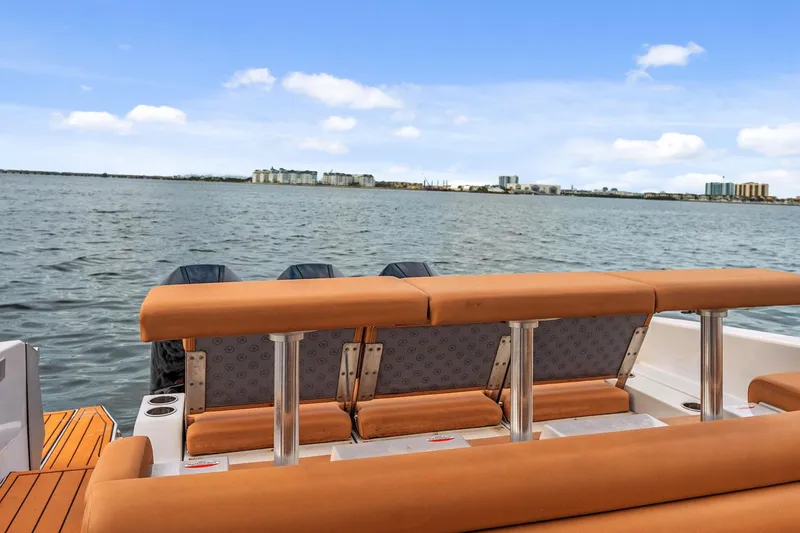 Slide: The Image of 2021 Aviara AV36 OB boat with tan seating, overlooking a calm waterfront cityscape. - 23