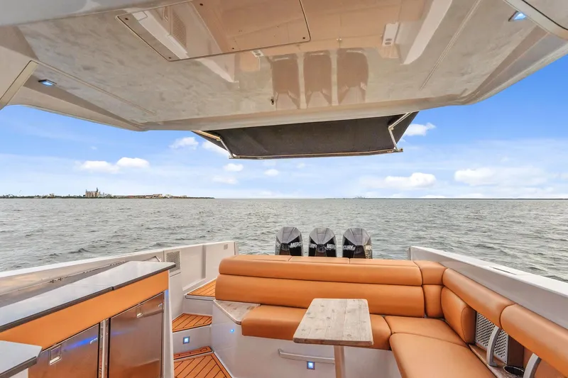 Slide: The Image of 2021 Aviara AV36 OB boat interior with tan seating, table, and ocean view. - 26
