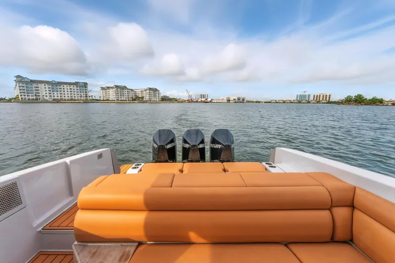 Slide: The Image of 2021 Aviara AV36 OB boat with tan seating, triple Mercury outboards, and waterfront view. - 28