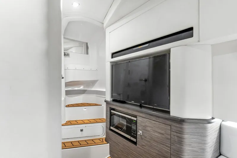 Slide: The Image of Interior of 2021 Aviara AV36 OB boat with TV, microwave, and wooden steps. - 36