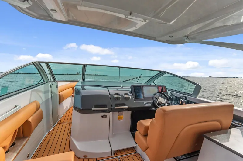 Slide: The Image of 2021 Aviara AV36 OB boat interior with modern helm and tan seating on open water. - 8