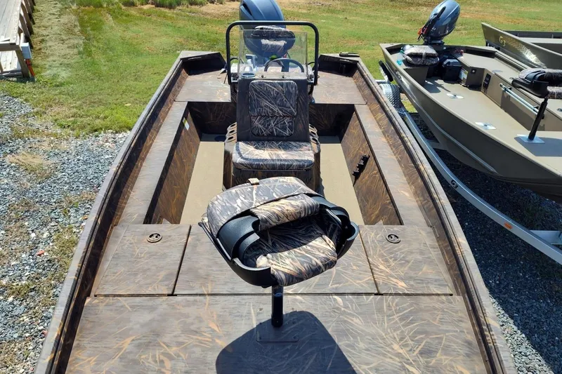 Slide: The Image of 2025 G3 Gator Tough 18 CC boat with camo seats, parked on gravel. - 2