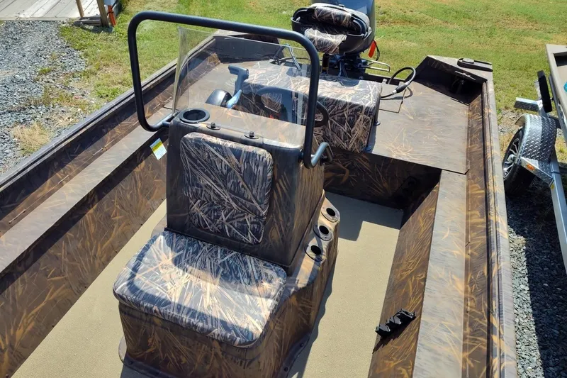 Slide: The Image of 2025 G3 Gator Tough 18 CC boat with camouflage seating and console, parked on grass. - 3