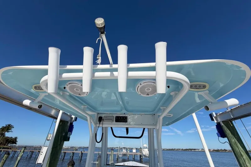 Slide: The Image of 2019 Sea Hunt Ultra 275 SE boat with rod holders and speakers, docked under clear blue sky. - 11