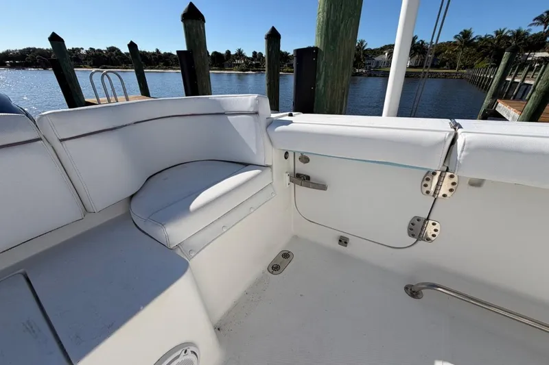 Slide: The Image of 2019 Sea Hunt Ultra 275 SE boat interior with white seating and waterfront view. - 13
