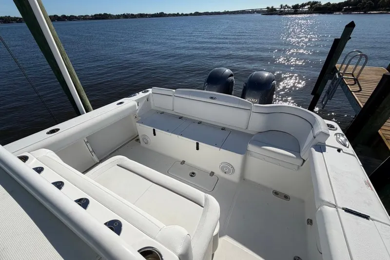Slide: The Image of 2019 Sea Hunt Ultra 275 SE boat interior with seating, docked by the water. - 3