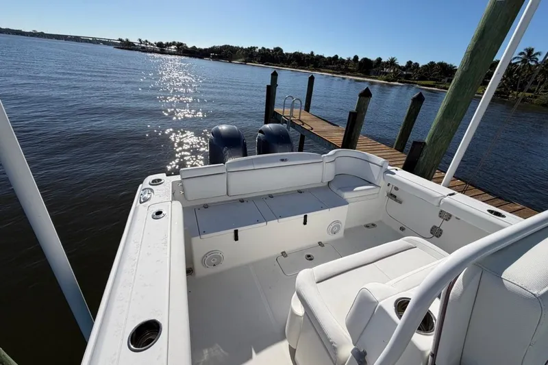 Slide: The Image of 2019 Sea Hunt Ultra 275 SE boat docked by a serene waterfront. - 4