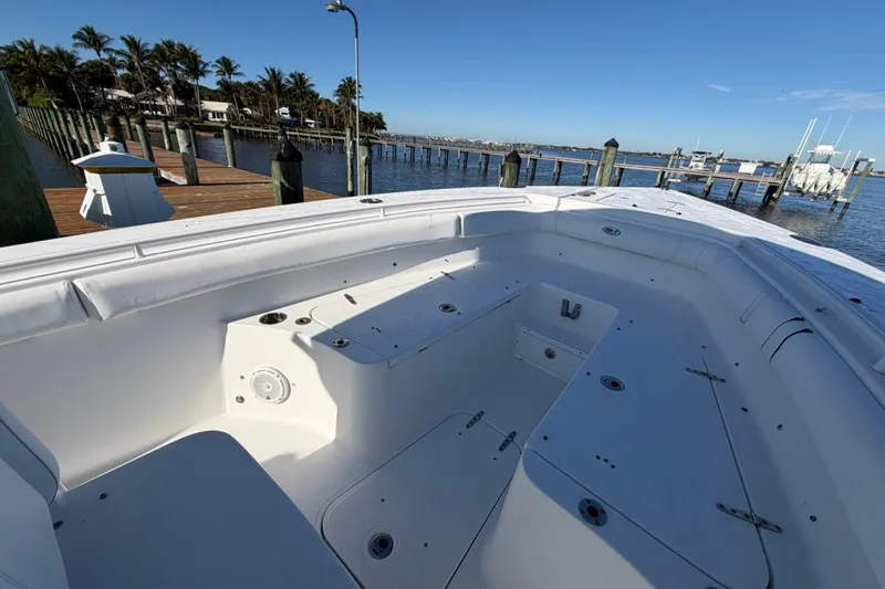 Slide: The Image of 2019 Sea Hunt Ultra 275 SE boat docked by a scenic waterfront. - 5