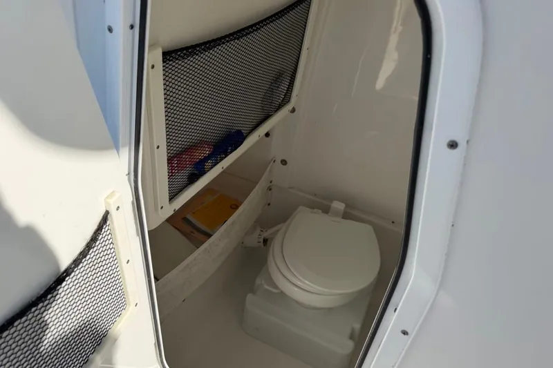 Slide: The Image of 2019 Sea Hunt Ultra 275 SE boat interior with compact marine toilet. - 9