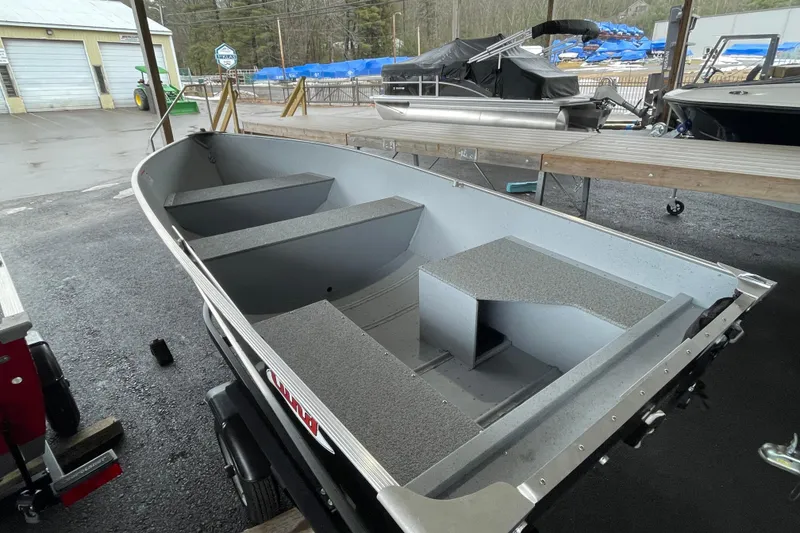 Slide: The Image of 2026 Lund WC-14 boat displayed outdoors, showcasing interior seating and storage. - 11