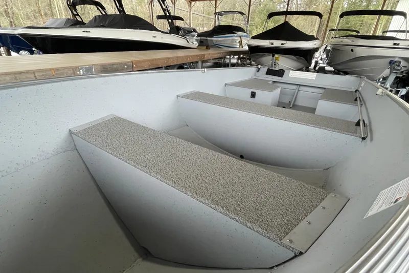Slide: The Image of 2026 Lund WC-14 boat interior with seating, stored in a covered area. - 13