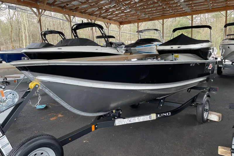 Slide: The Image of 2026 Lund WC-14 boat on trailer in covered storage area. - 14