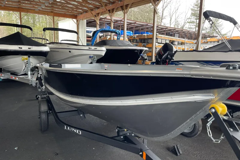 Slide: The Image of 2026 Lund WC-14 boat on trailer in covered storage area. - 15