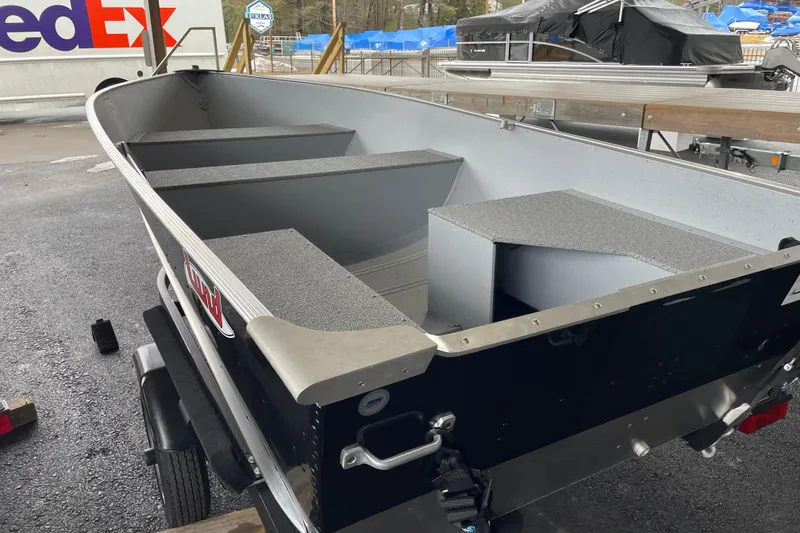 Slide: The Image of 2026 Lund WC-14 boat on trailer, parked outdoors near FedEx truck. - 9