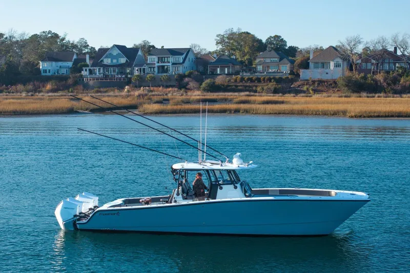 Slide: The Image of 2024 Freeman 38 boat on calm water with houses in the background. - 11