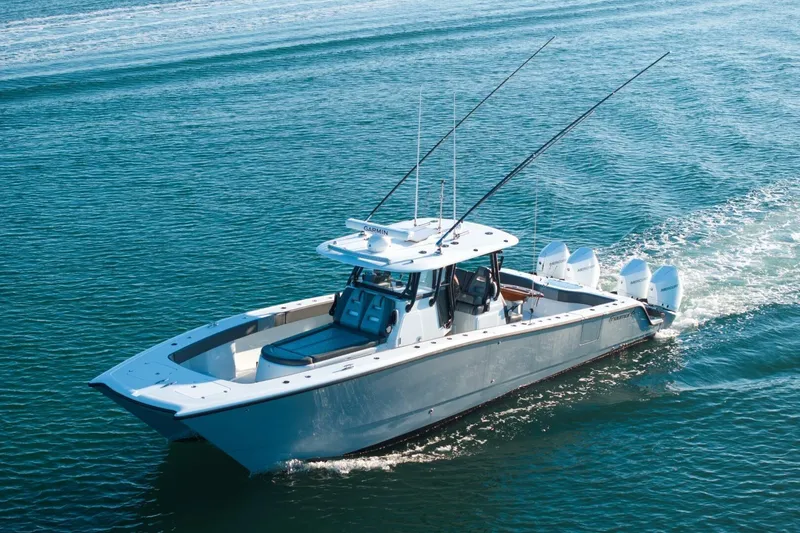 Slide: The Image of 2024 Freeman 38 boat cruising on open water with fishing rods and multiple engines. - 12