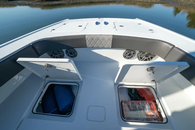Slide: The Image of Bow storage compartments on a 2024 Freeman 38 boat, featuring speakers and cushioned seating. - 15